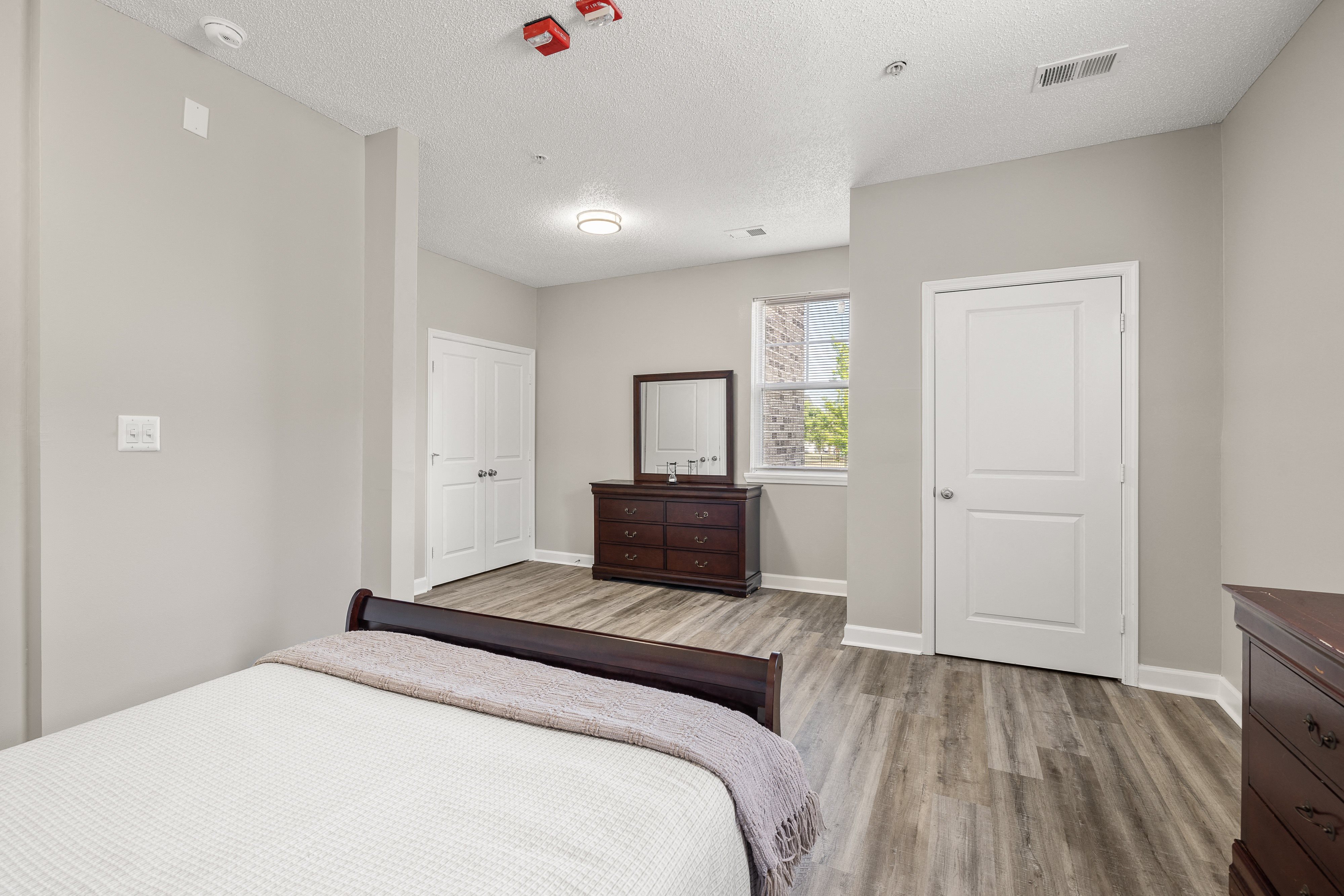 an empty bedroom with a bed and a dresser